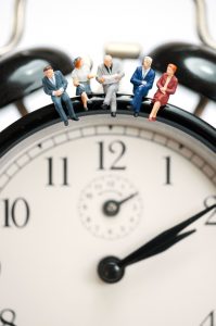 Miniature figures sitting on a clock.