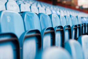 Empty blue stadium seats in rows.