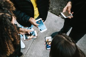 Group of people using smartphones outdoors.